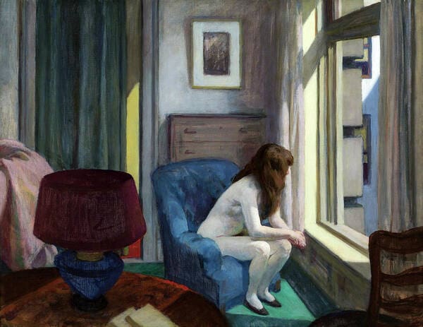 Woman sitting, looking out a window.